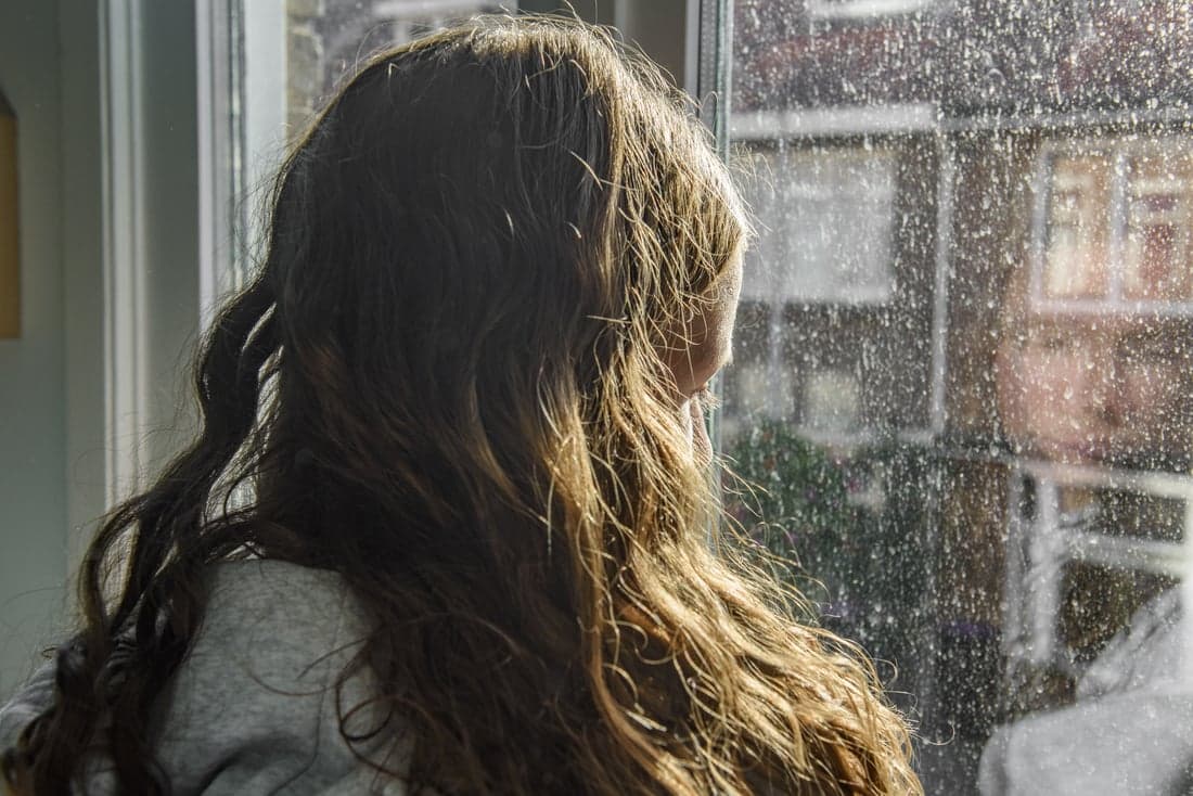 Meisje kijkt uit raam