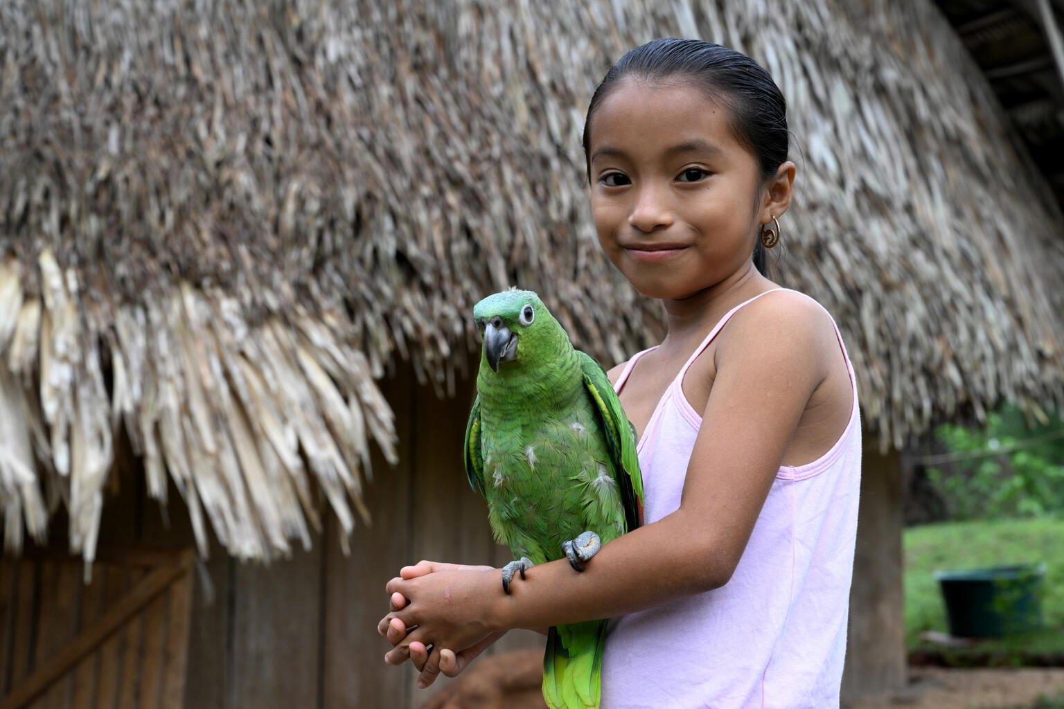 De achtjarige Emeldina met haar papegaai Jessy in Belize.