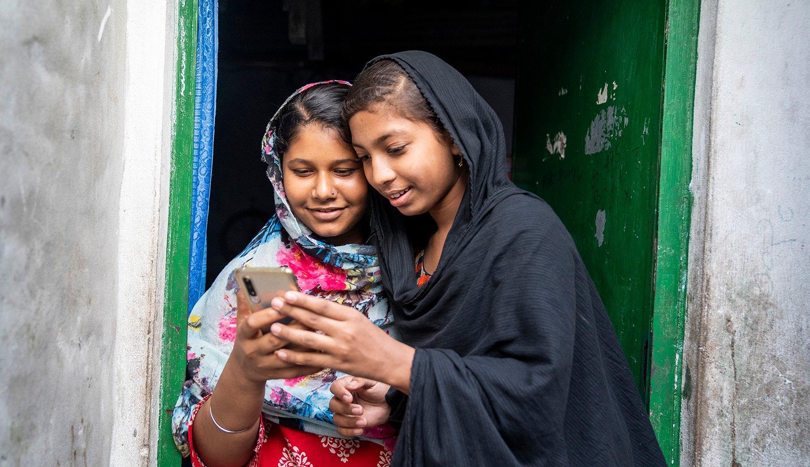 Meisjes in Bangladesh bellen met hun mobiele telefoon.