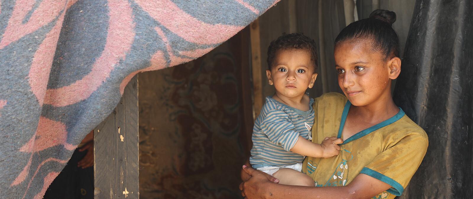 meisje houdt broertje vast in tent gaza