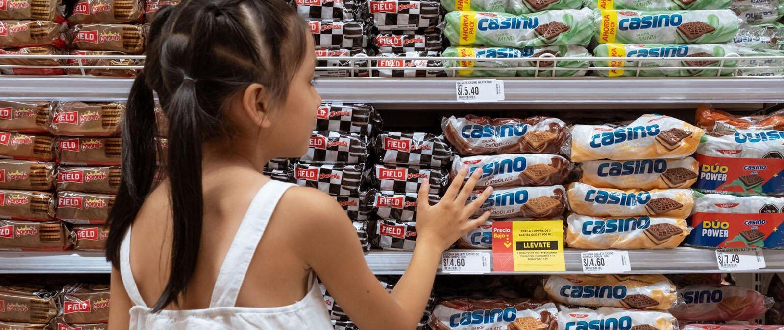 Micaella voor een schap in de supermarkt met ongezond voedsel