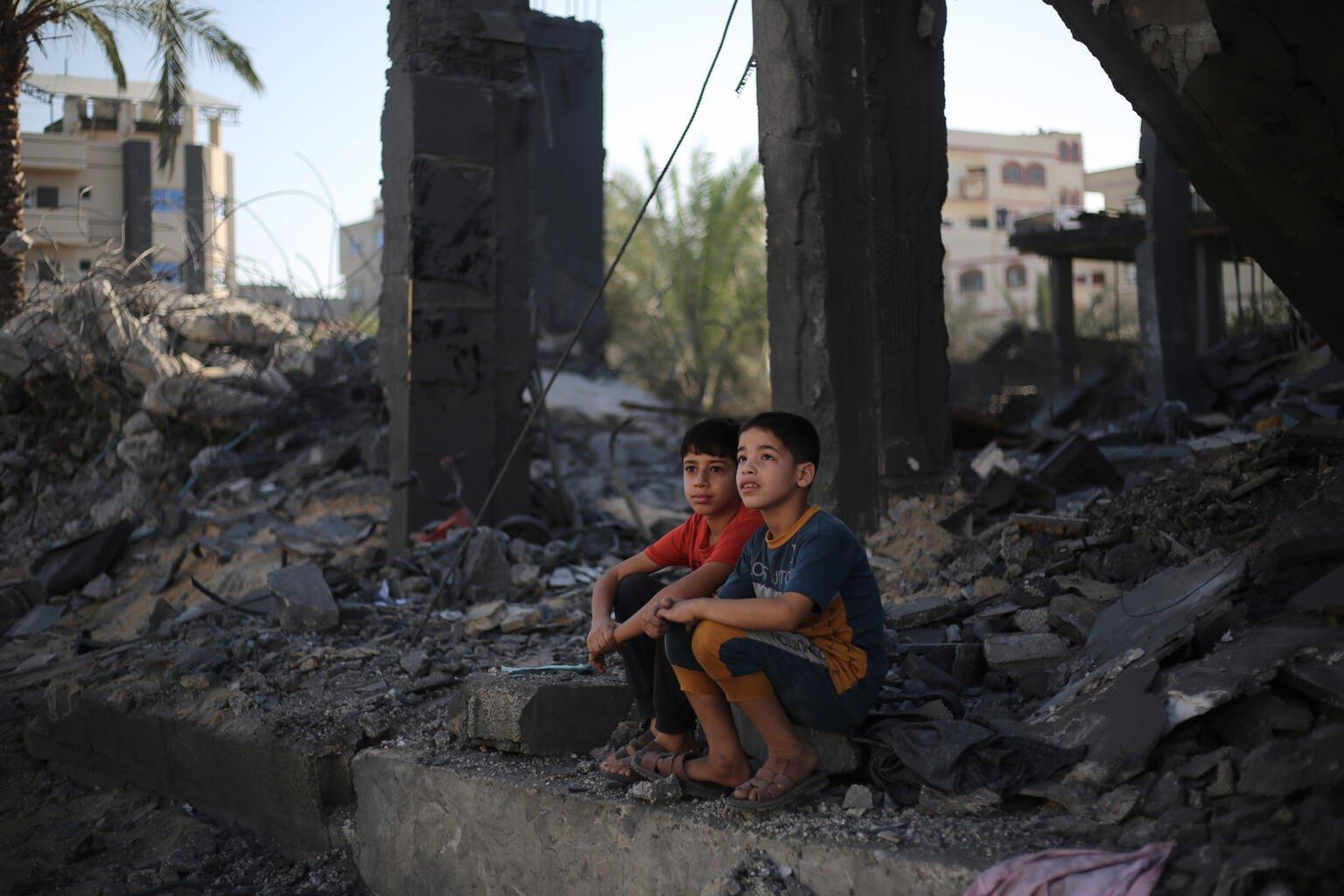 twee jongens kijken vanuit verwoest huis gaza