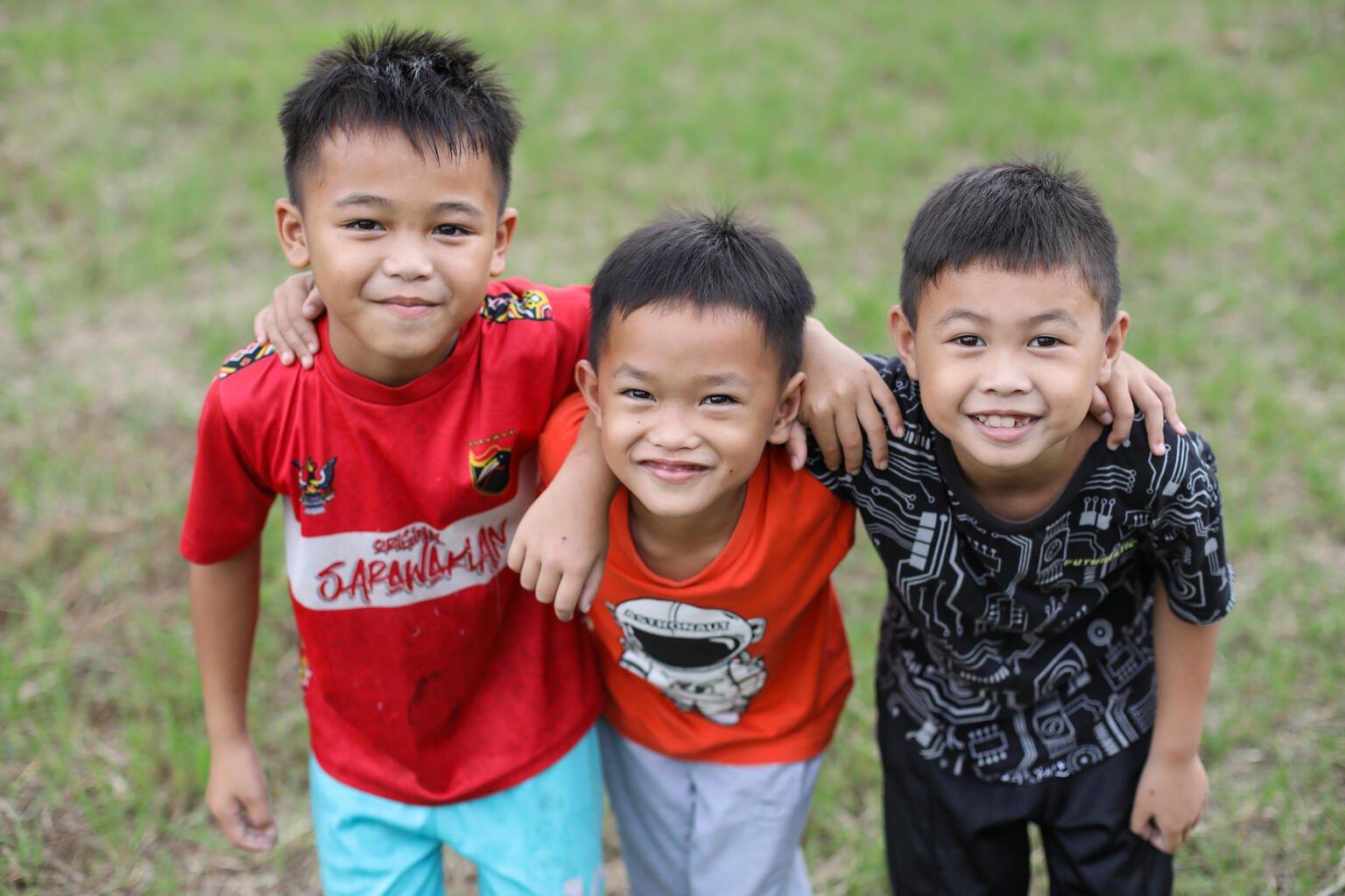 Drie kinderen omhelzen elkaar
