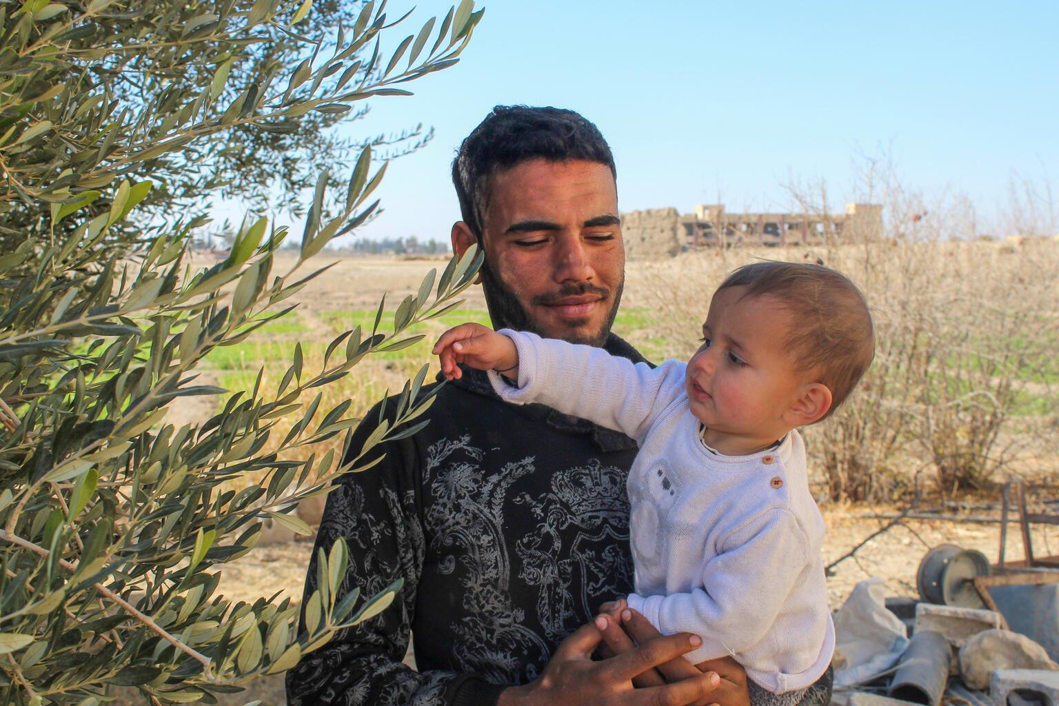 De Syrische baby Morei zit bij zijn vader op de arm.