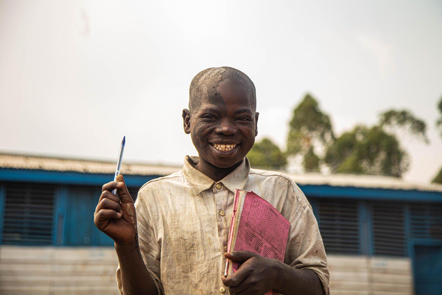 Jongen uit DR Congo met schoolspullen in de hand