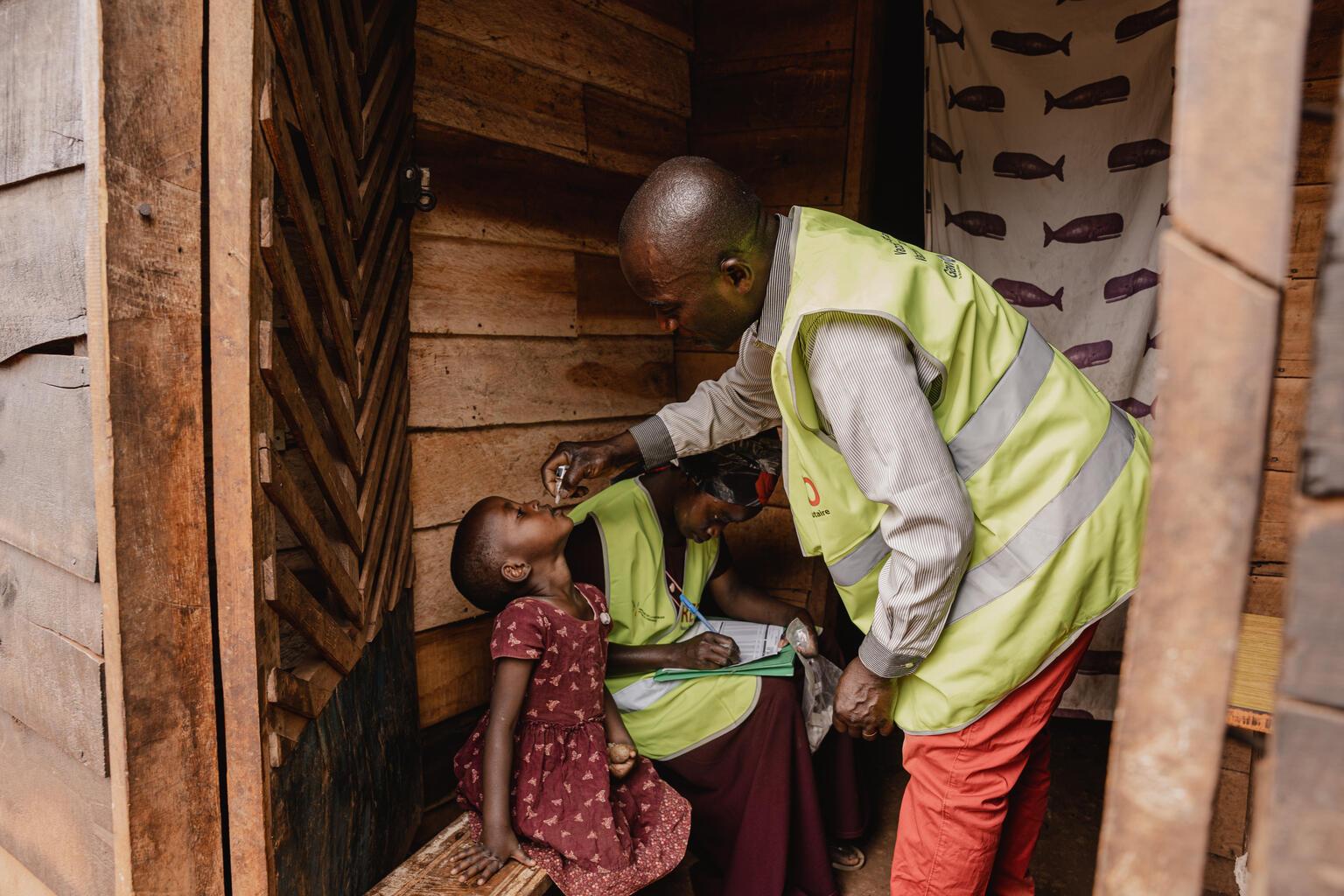 UNICEF-medewerker geeft kind poliovaccin