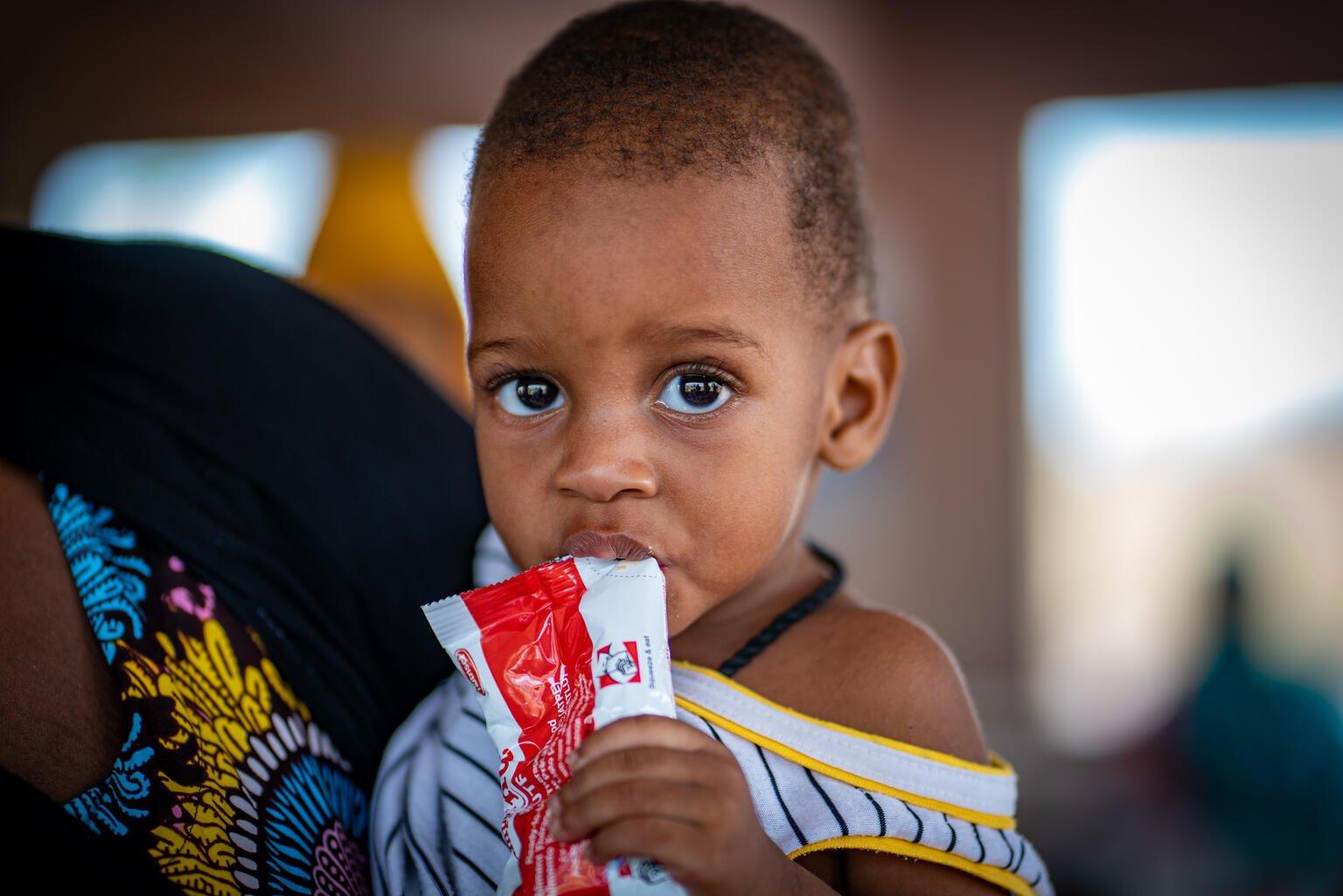 Baby van negen maanden eet een plumpy nut in Mali
