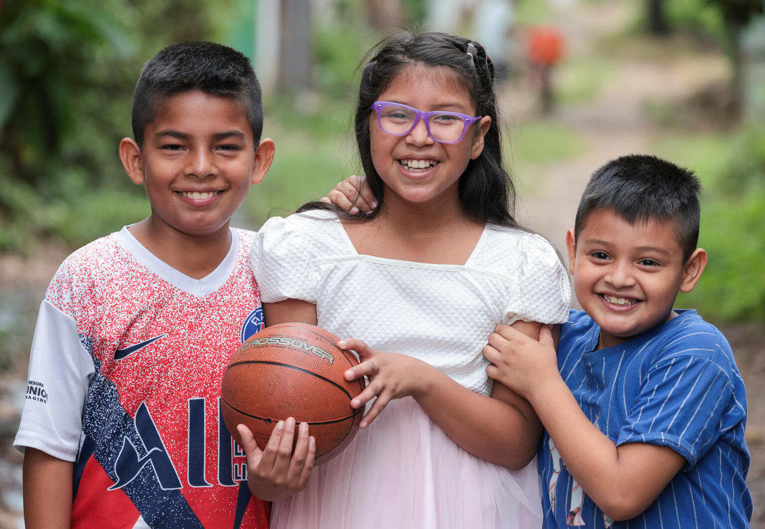 Broers en zus spelen samen met bal in El Salvador