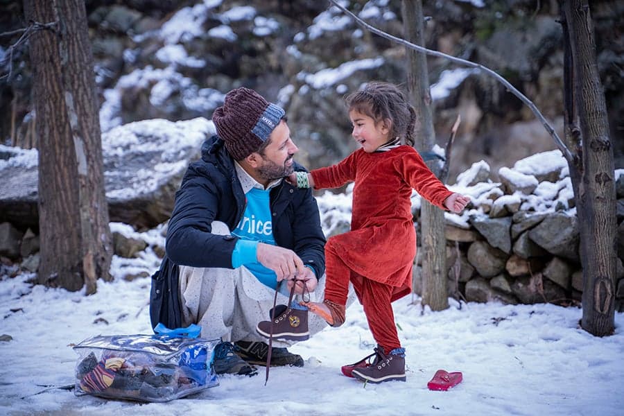 UNICEF medewerker Pakistan geeft meisje schoenen