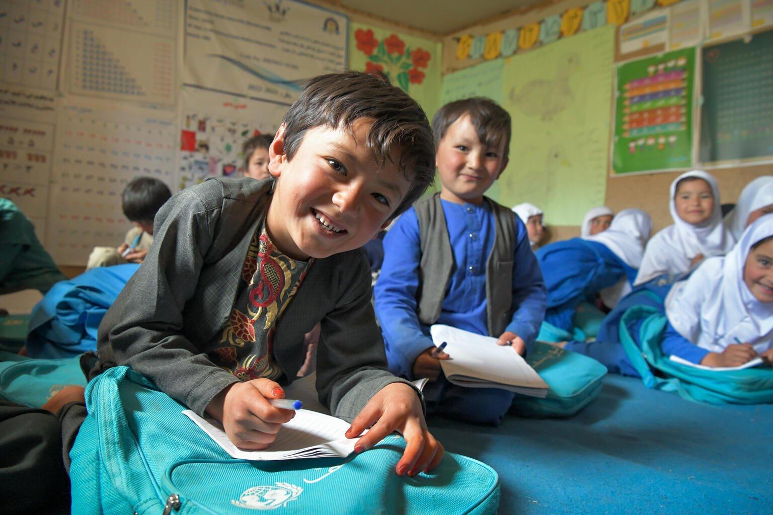Lachende jongen in een klas in Afghanistan