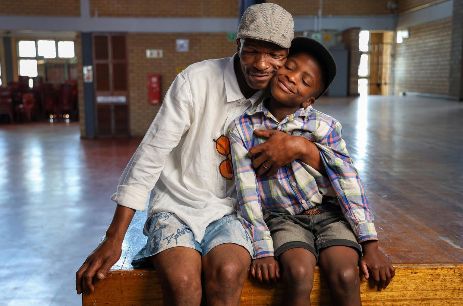 Vader knuffelt zijn zoon in Zuid Afrika