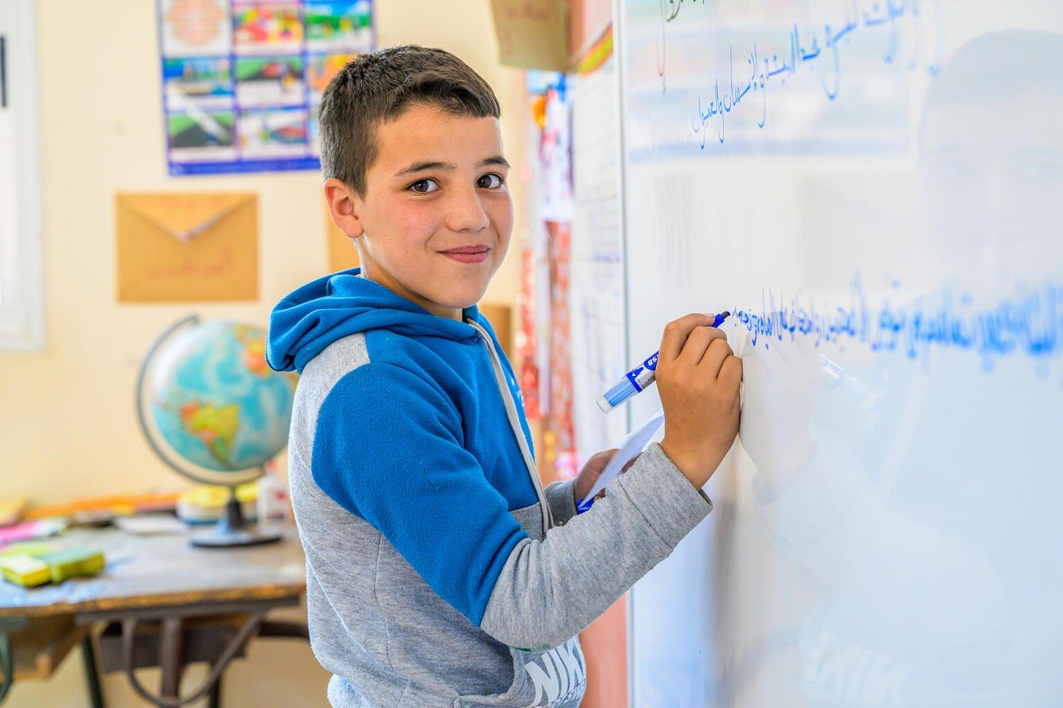 Jongen uit Marokko schrijft op een schoolbord