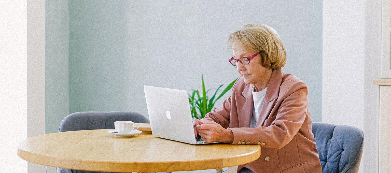 oudere dame achter laptop aan tafel