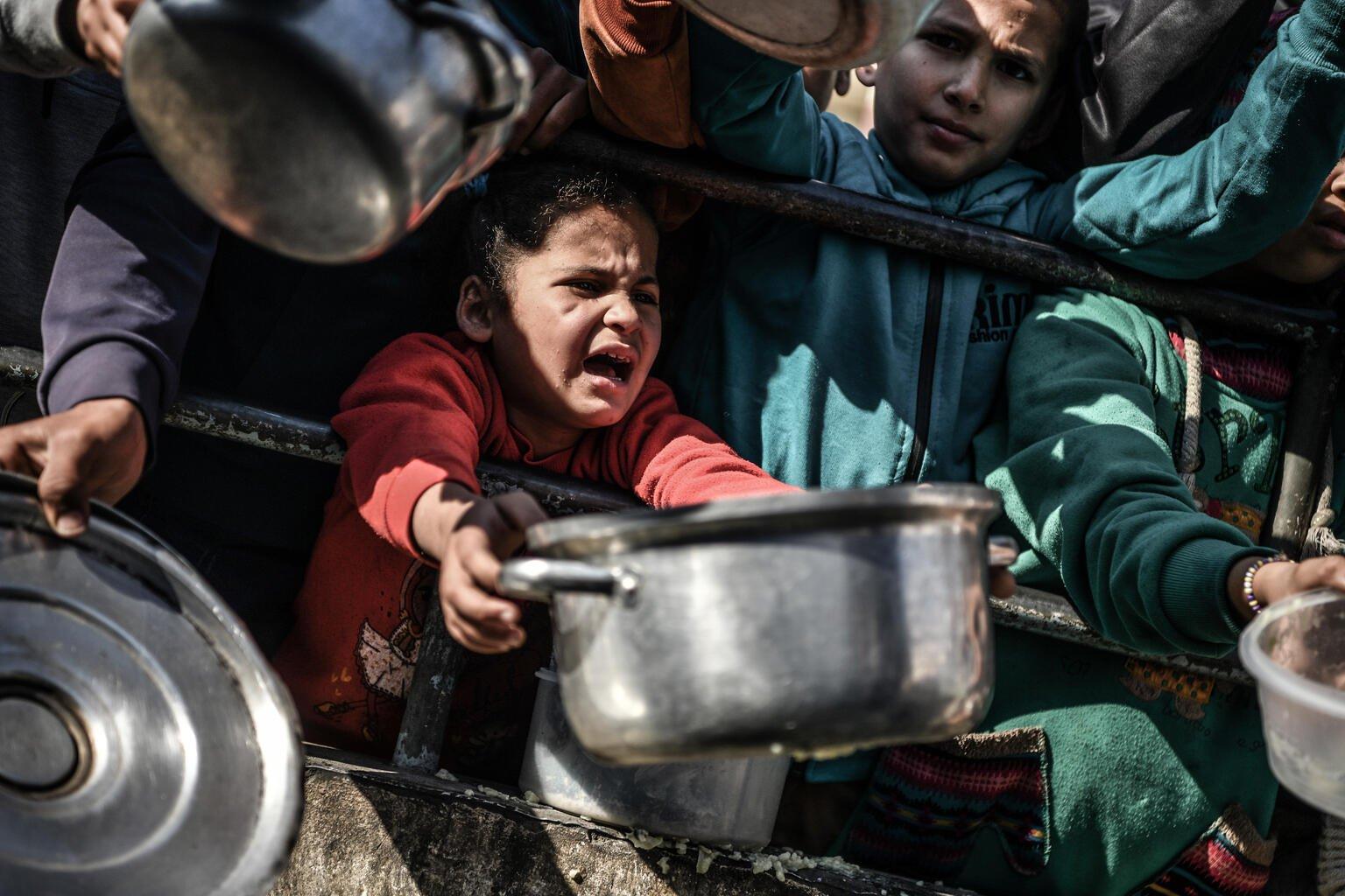 Een meisje staat in de rij voor voedsel in Gaza.