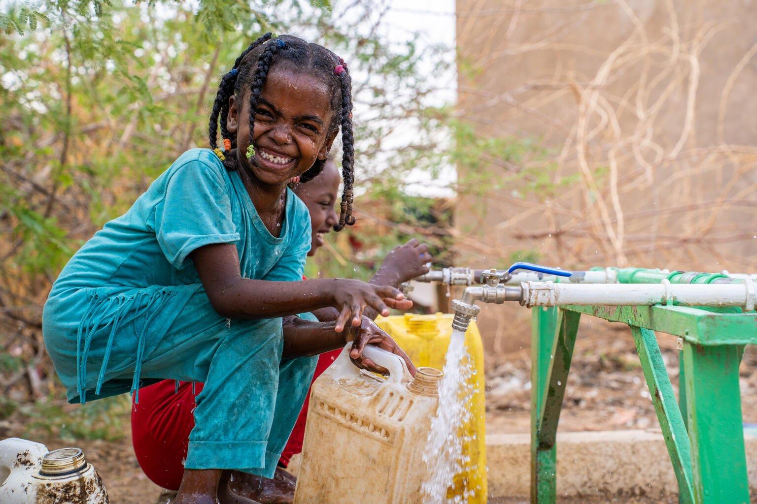 Meisje vult een watertank met schoon water
