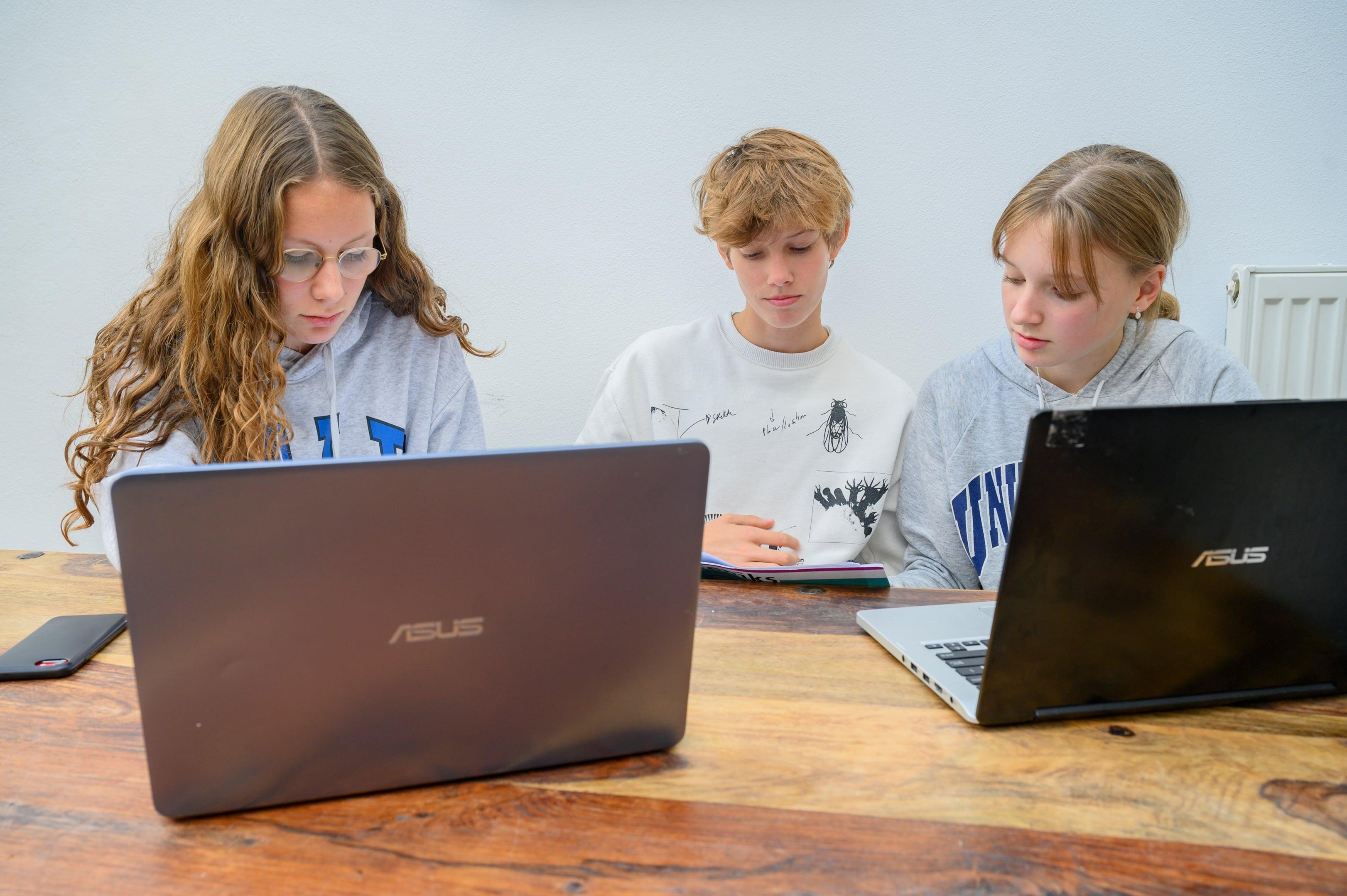 drie kinderen die achter een computer zitten