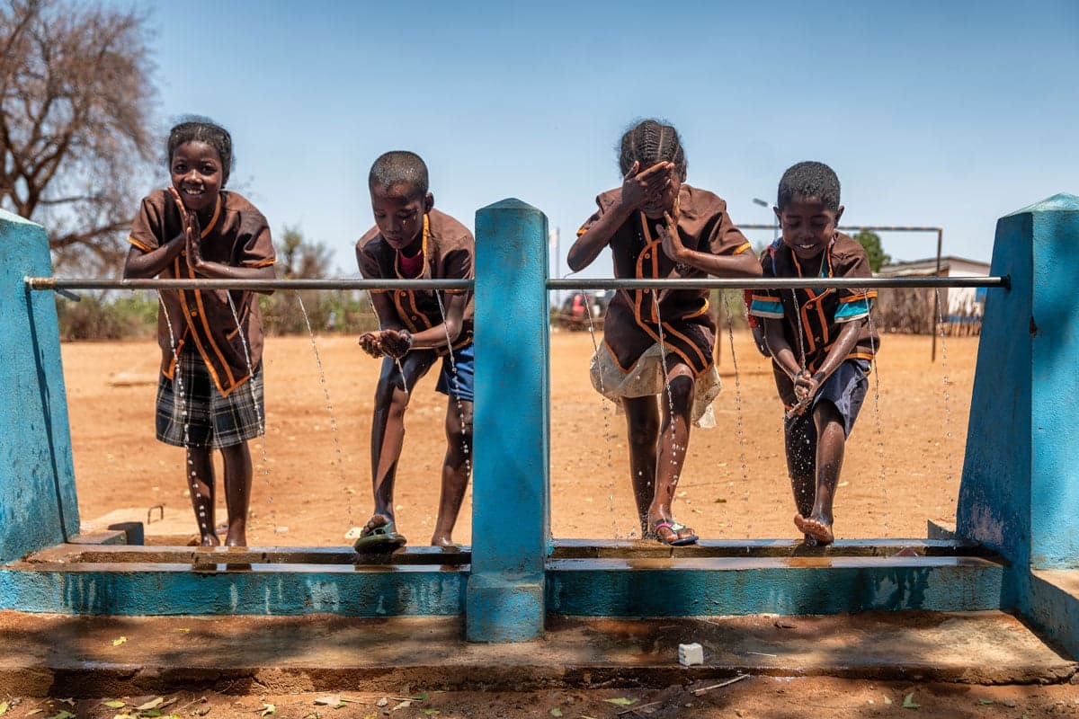 Kinderen in Madagaskar bij waterkraan