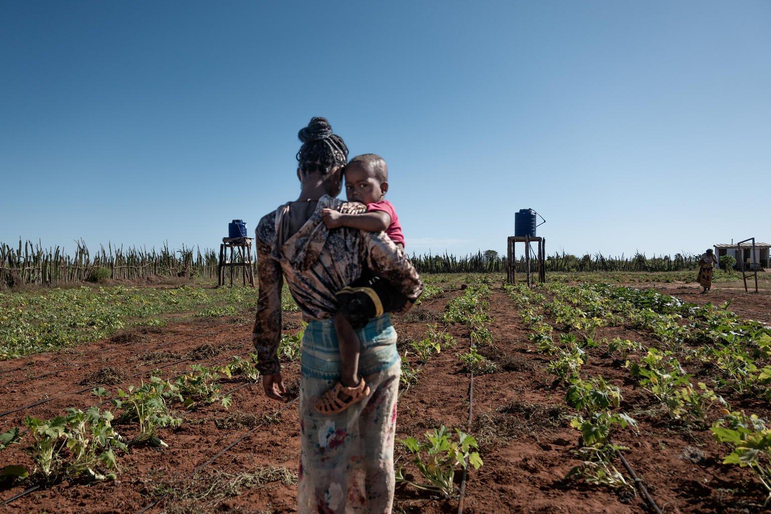 Vrouw met kind voor watertoren in Madagaskar