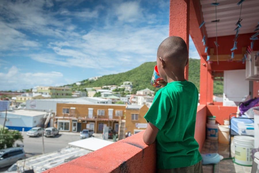 jongen op balkon kijkt naar uitzicht, st maarten