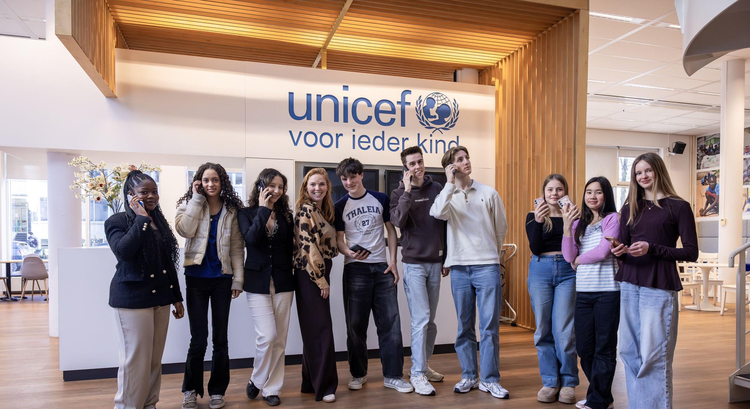 jongeren van jongerenraad met mobieltjes op unicef-kantoor