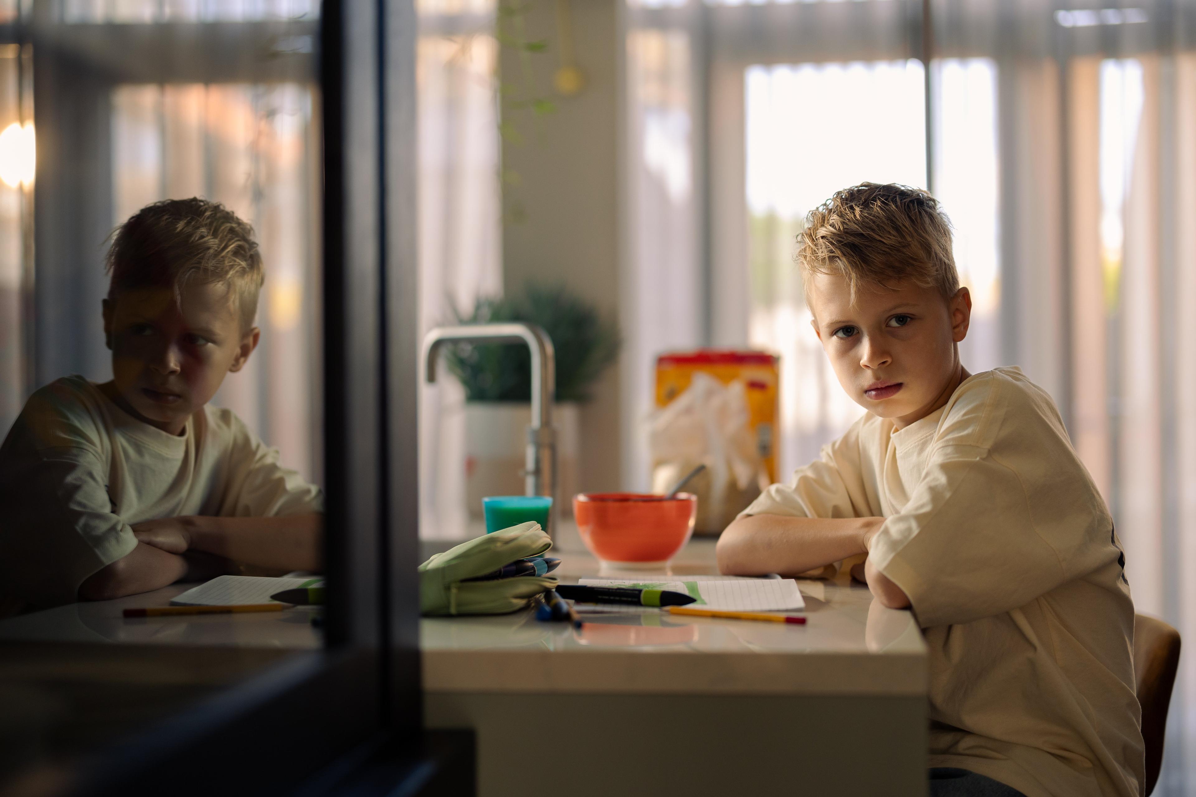 Foto van Logan, jongen met blond haar aan tafel voor de verkiezingscampagne