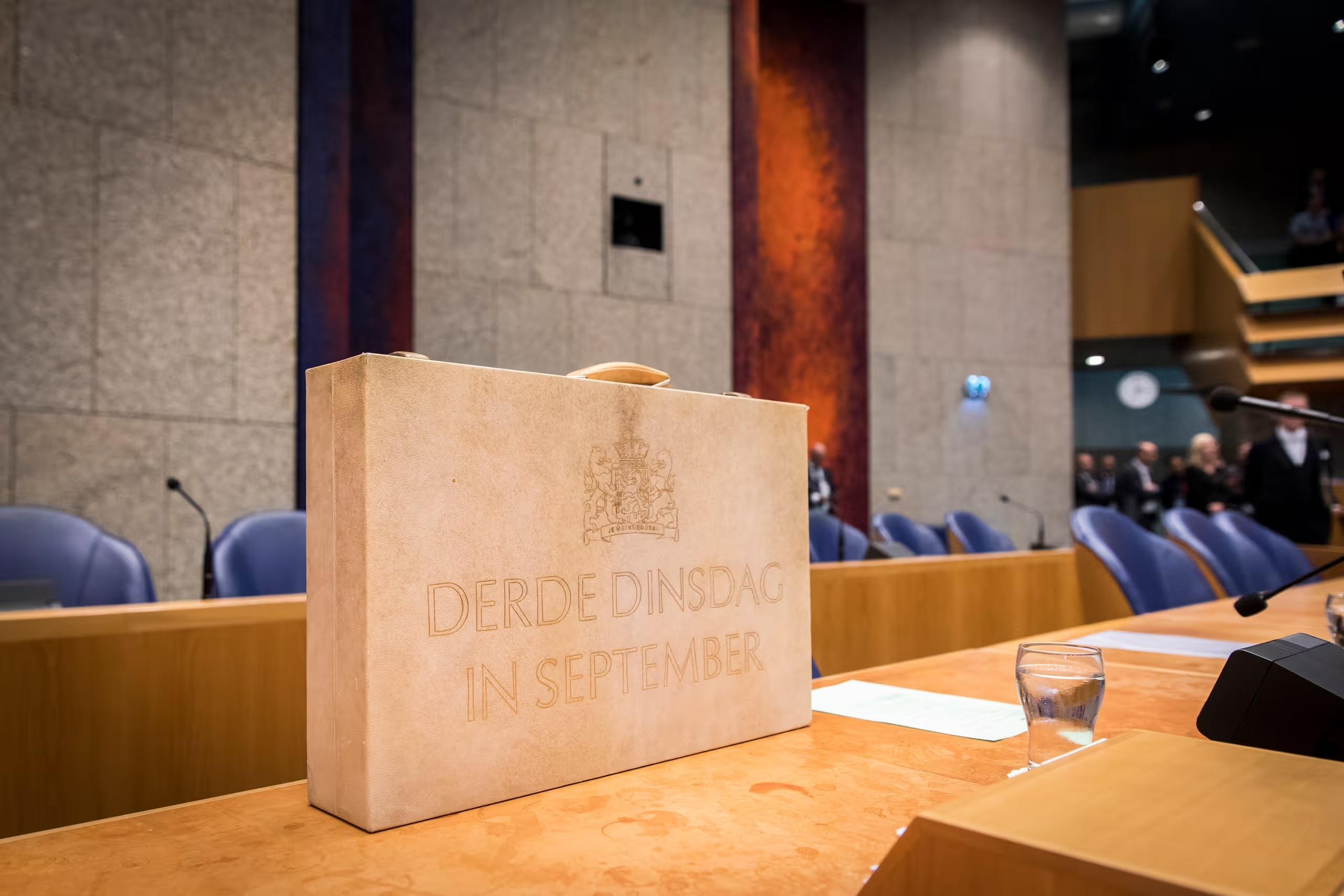 Het koffertje in de kamer met blauwe stoelen in de achtergrond te zien