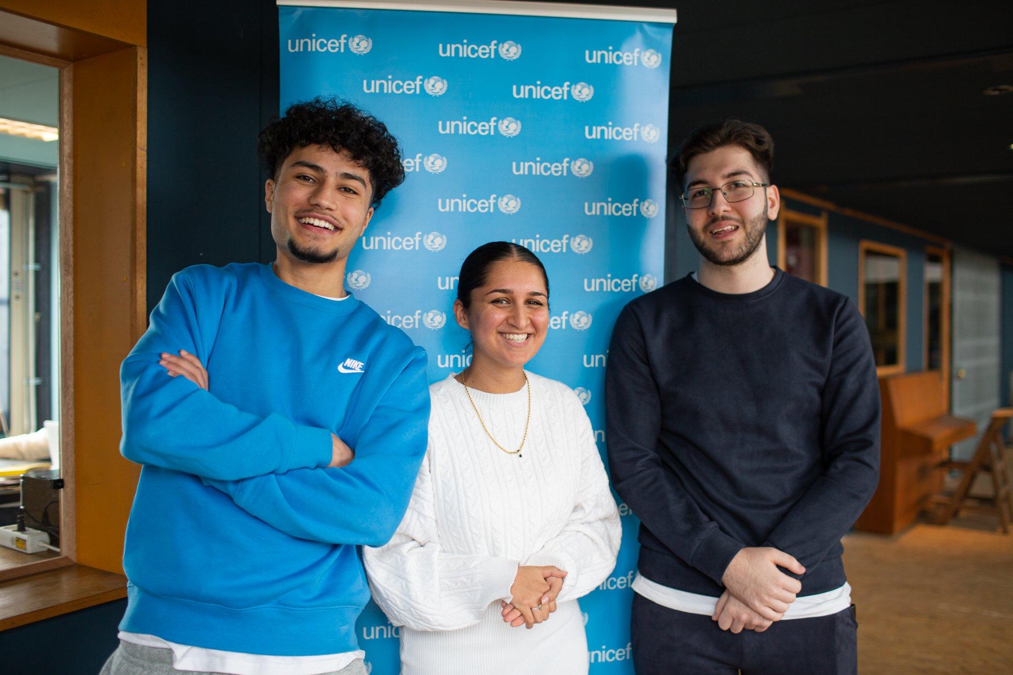 Jongeren staan voor een UNICEF-banner.