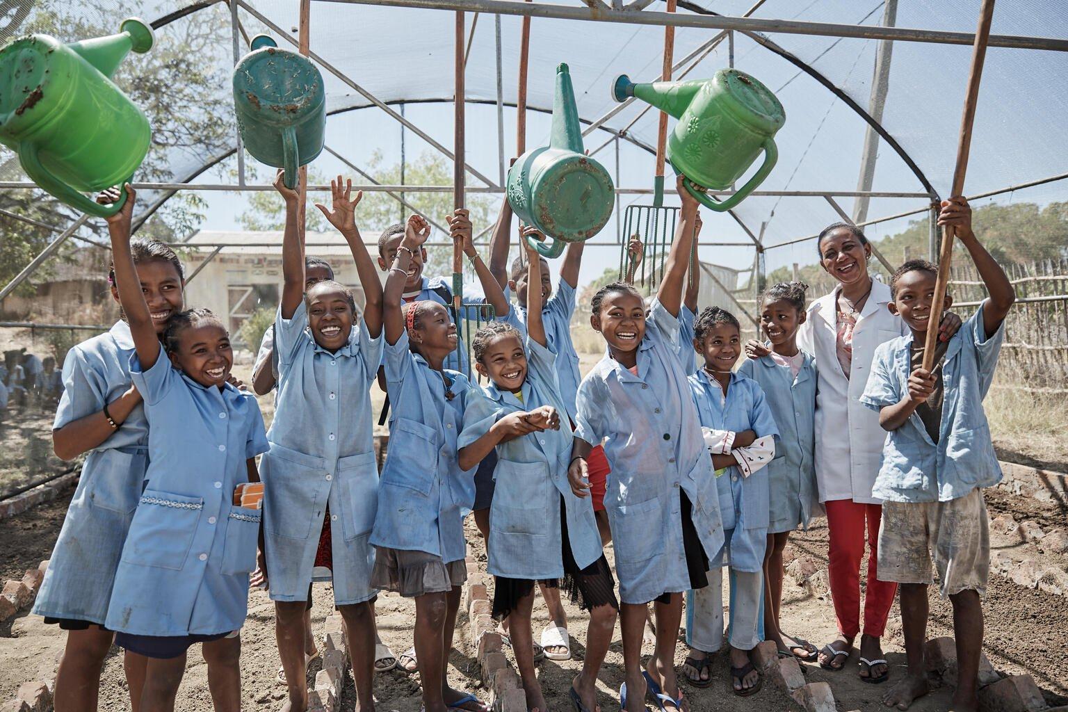 Kinderen in madagaskar met gieters voor hun bomenproject