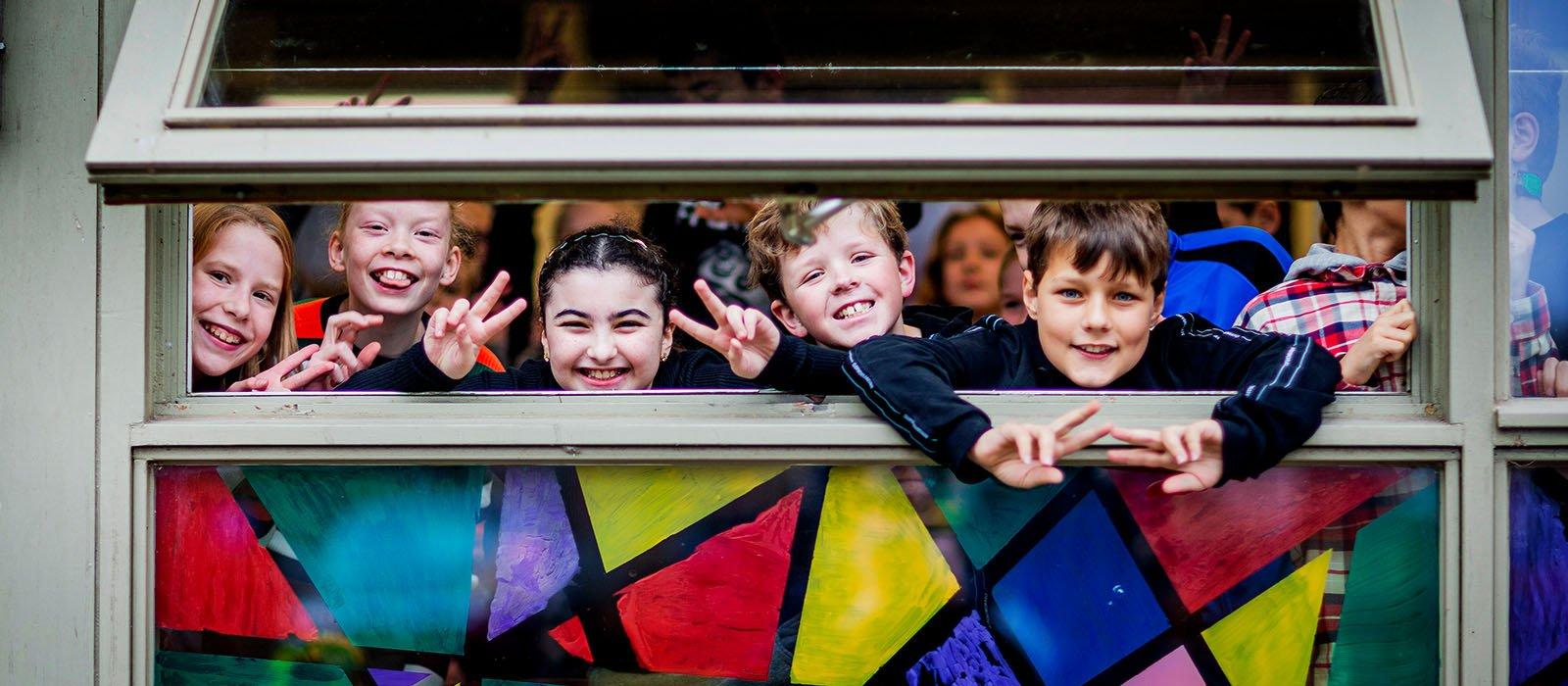 Kinderen-kijken-uit-schoolklasraam