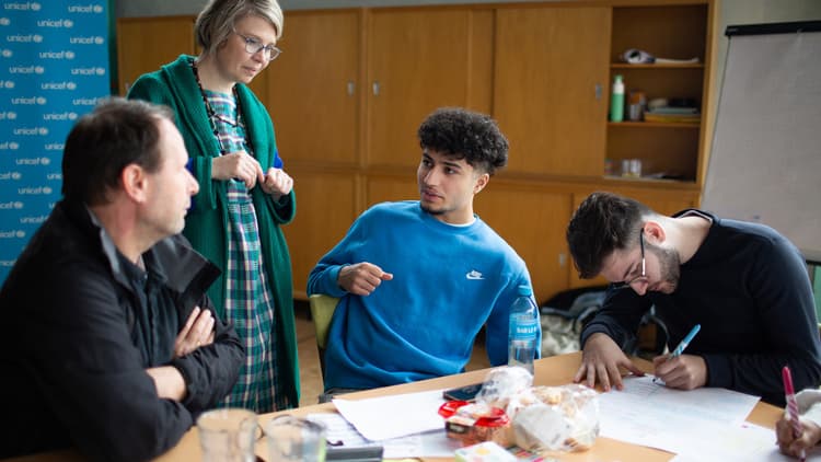 Jongeren aan tafel met leerkrachten op middelbare school
