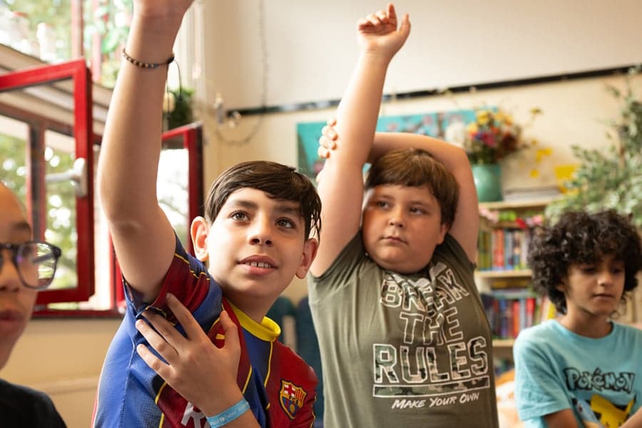 jongens steken vinger op in de klas