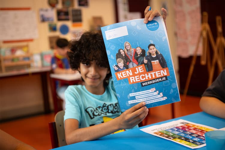Jongen houdt ken je rechten werkboekje op