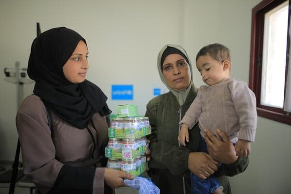 Jongentje en zijn oma ontvangen voedselhulp van UNICEF in Gaza.