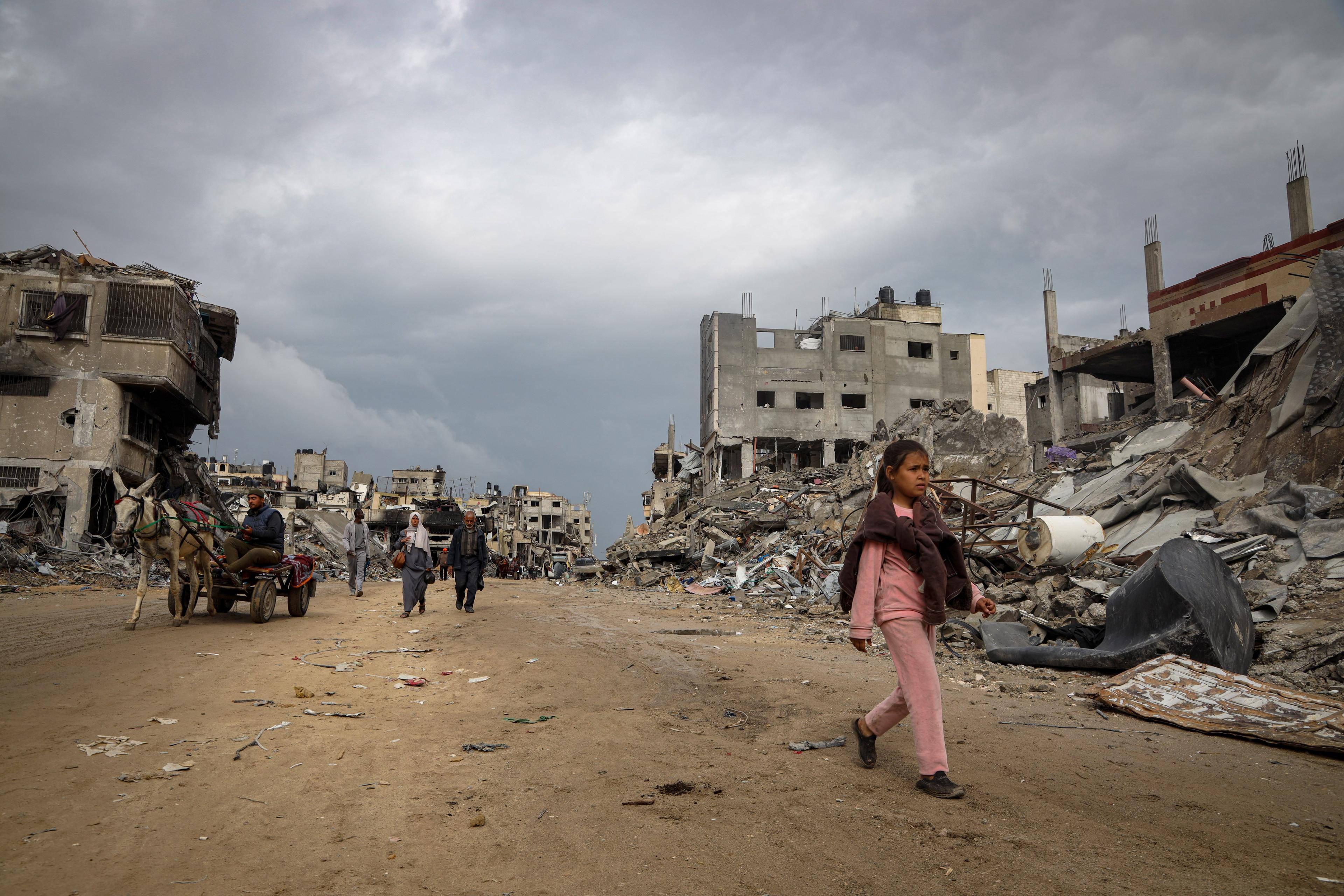 De 10-jarige Sama loopt door het puin van haar verwoeste wijk in Gaza.