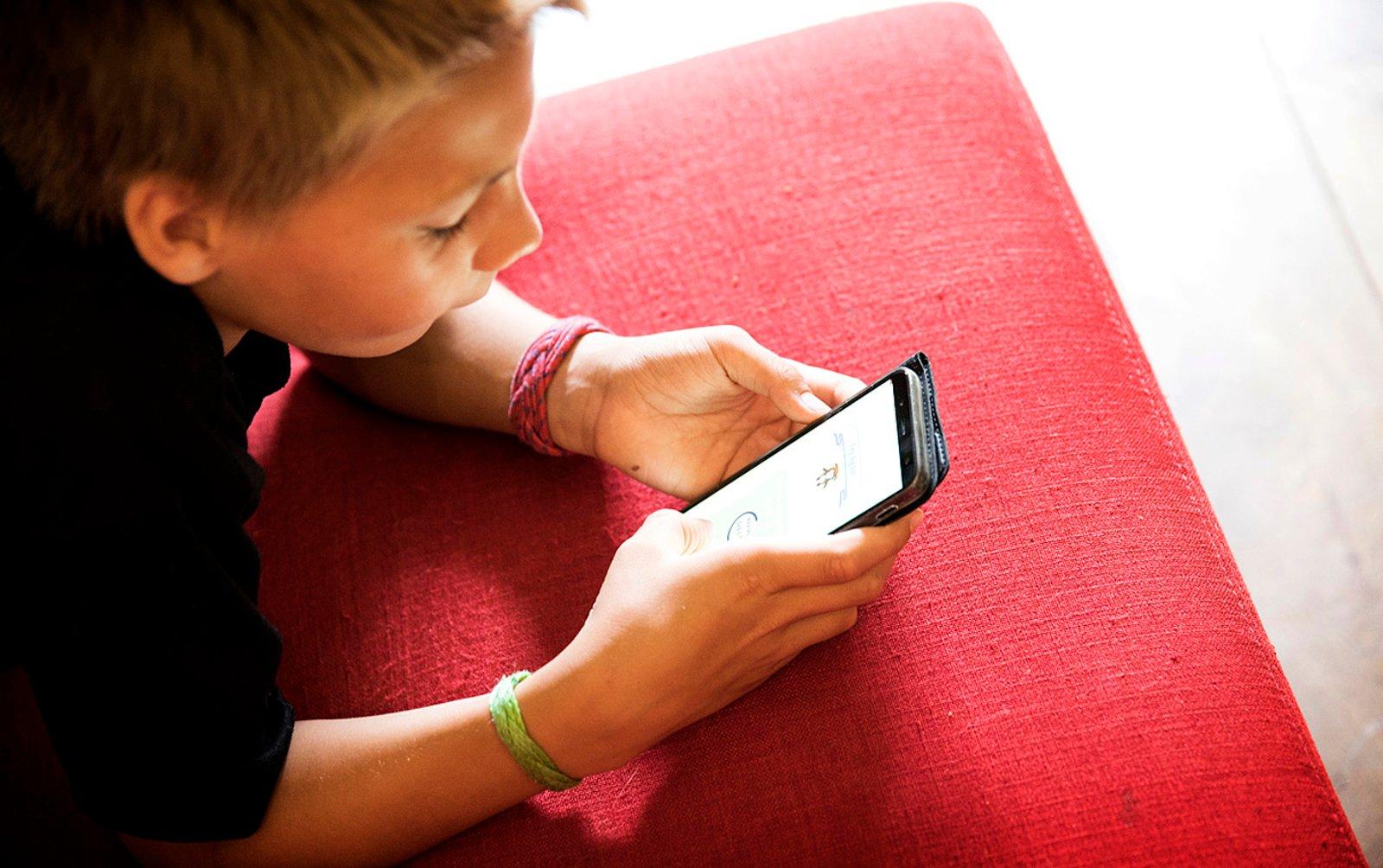 Kind scrolt op zijn telefoon.
