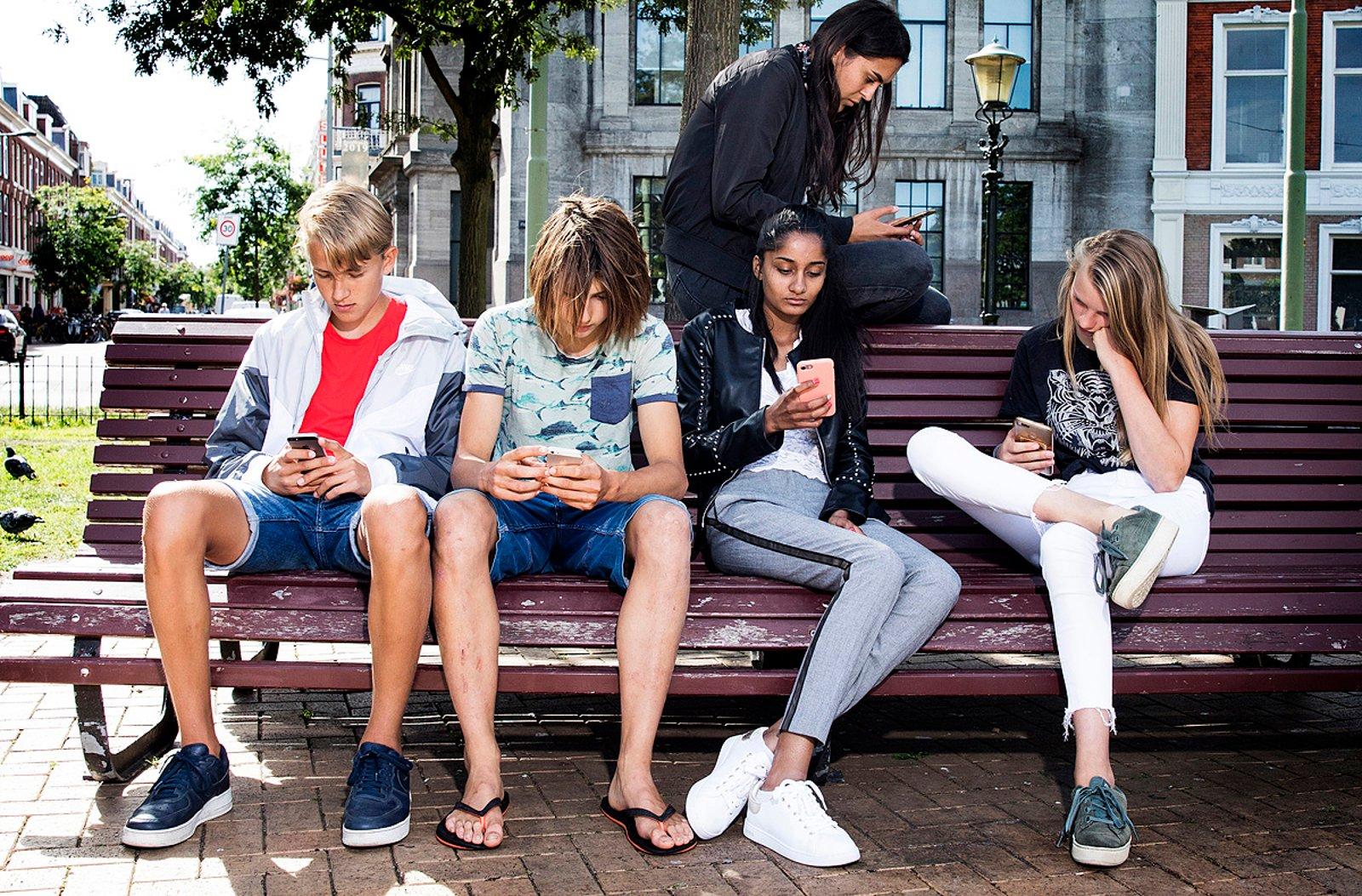 Nederlandse jongeren scrollen op hun telefoon.