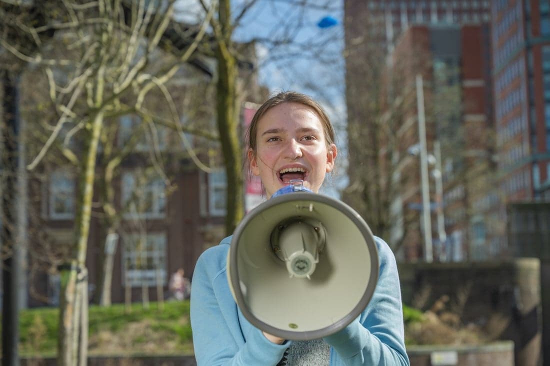 Meisje roept door een megafoon.