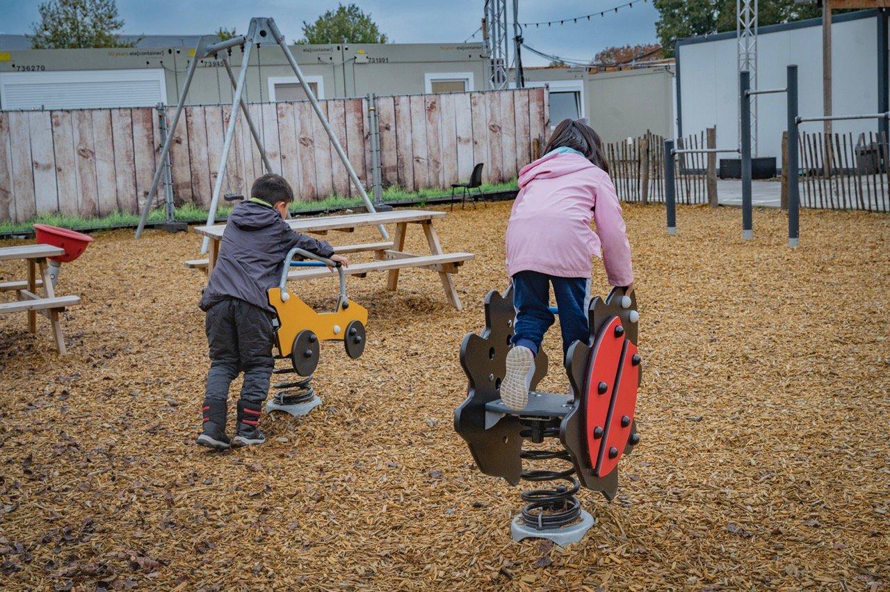 Kinderen in noodopvang spelen in speeltuin