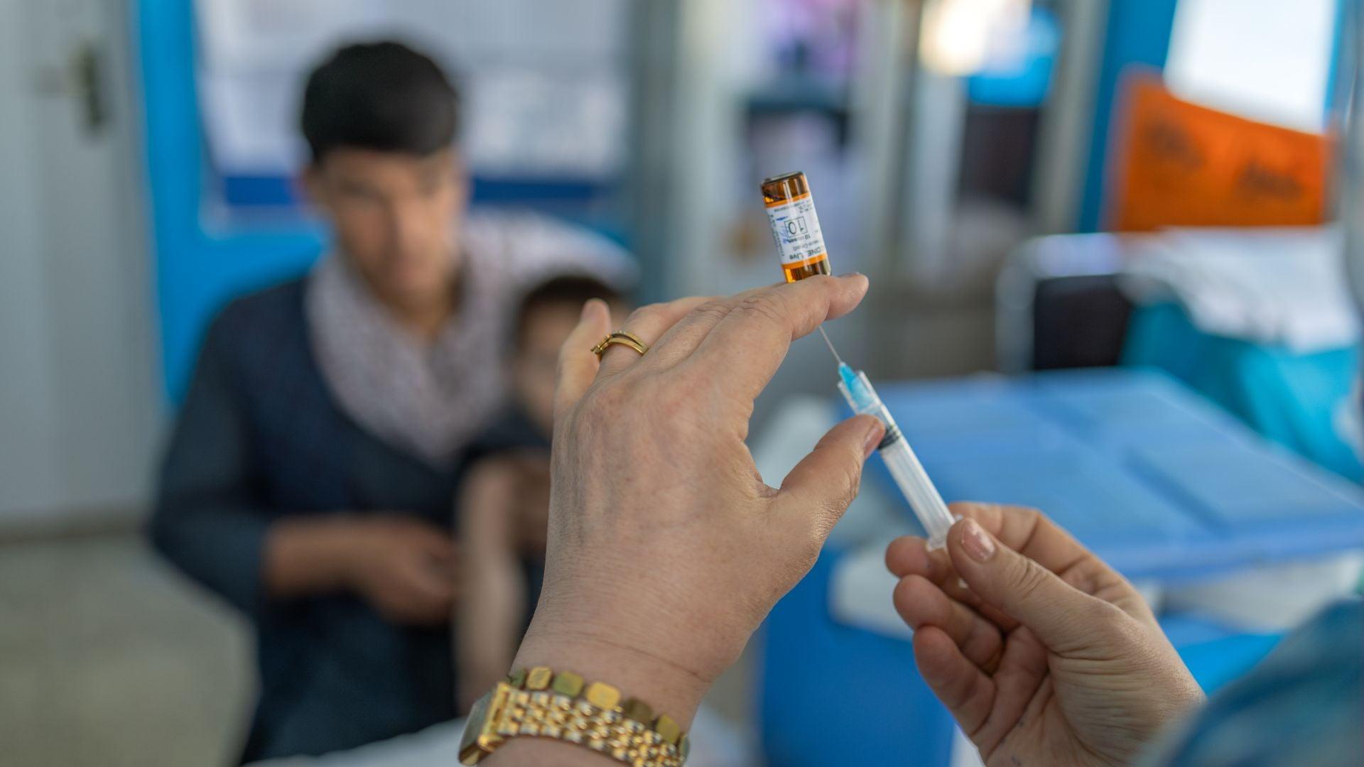 twee handen houden een vaccinatiespuit vast