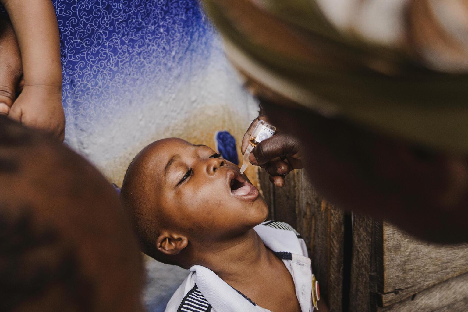 jongen ontvangt polio vaccinatie in congo van unicef