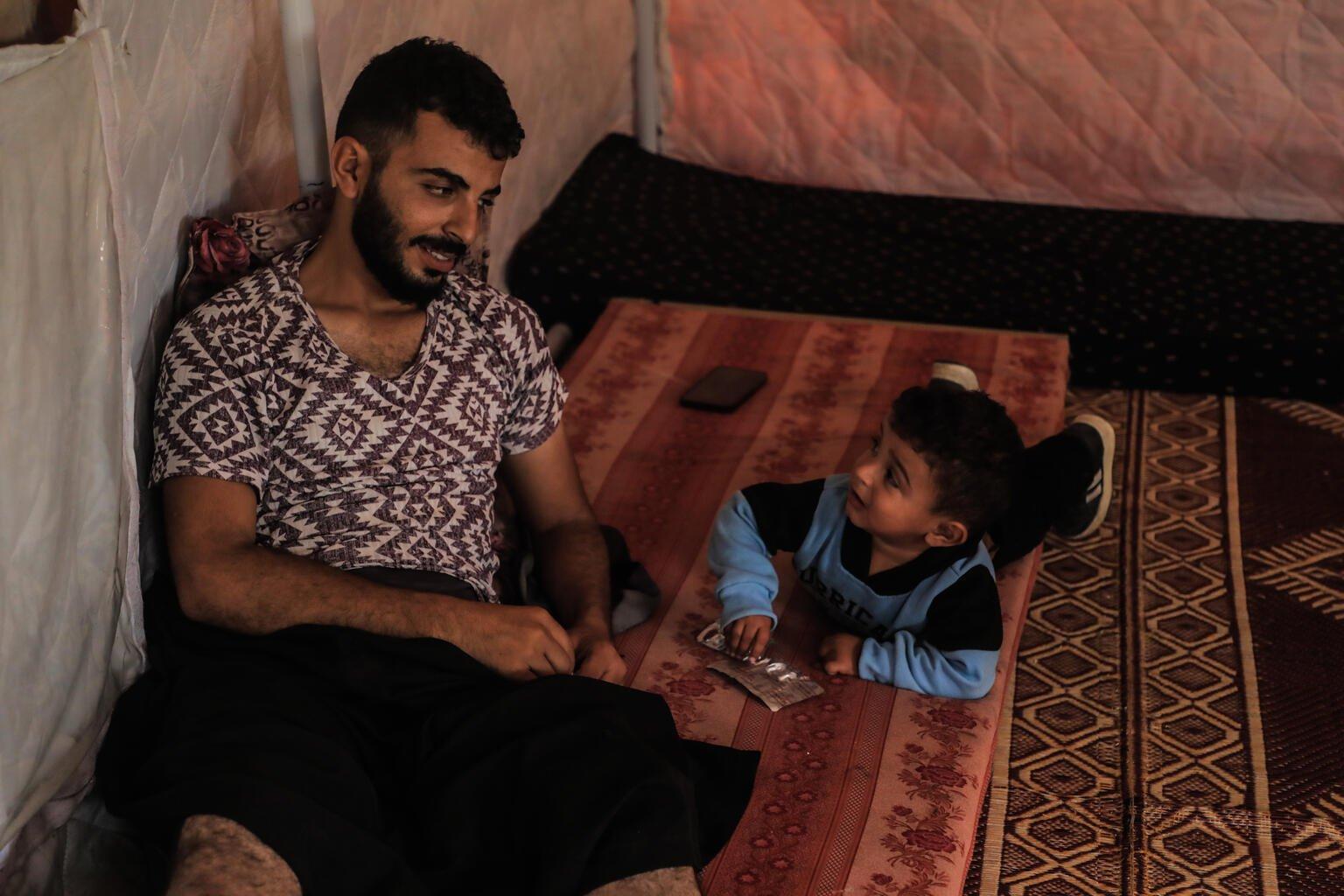 Vader en zoon in tent op de grond in Gaza