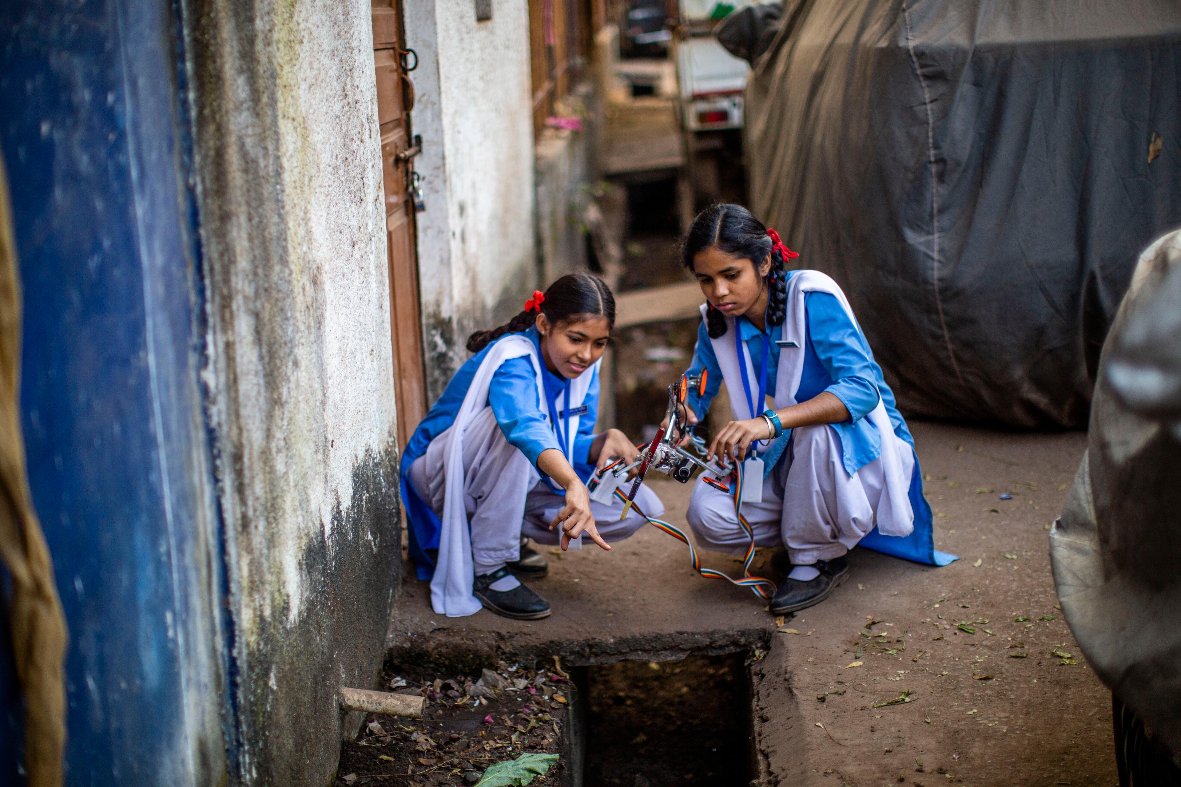twee studenten meten de rioolpijpen voor hun robot prototype