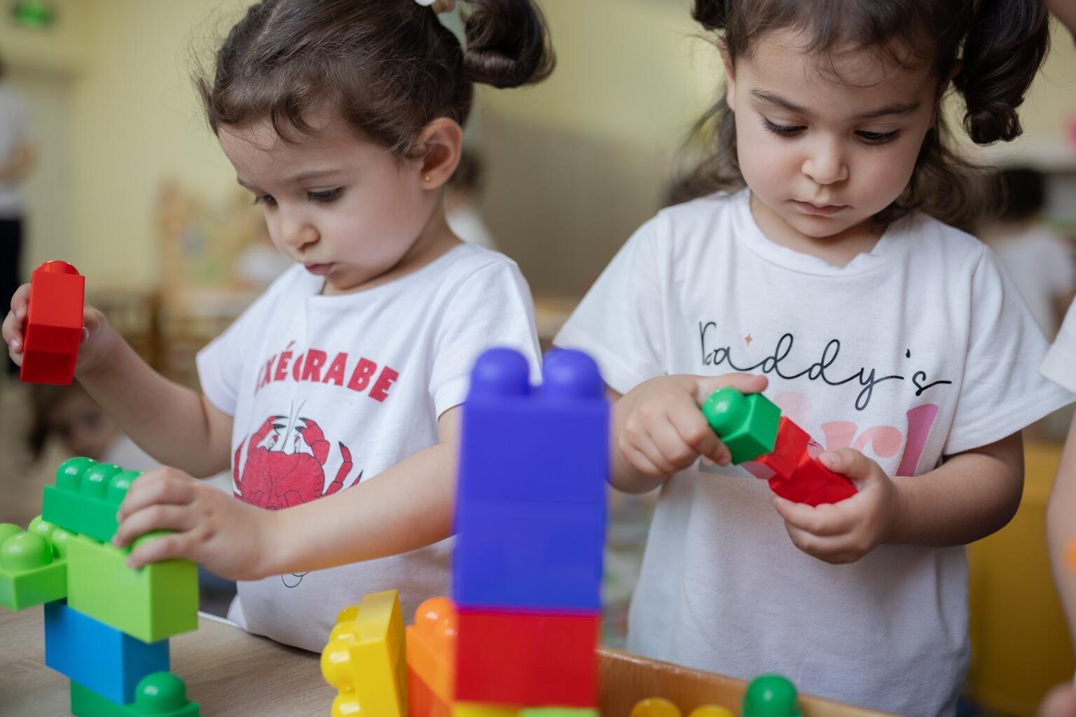 Twee meisjes spelen met blokken op school