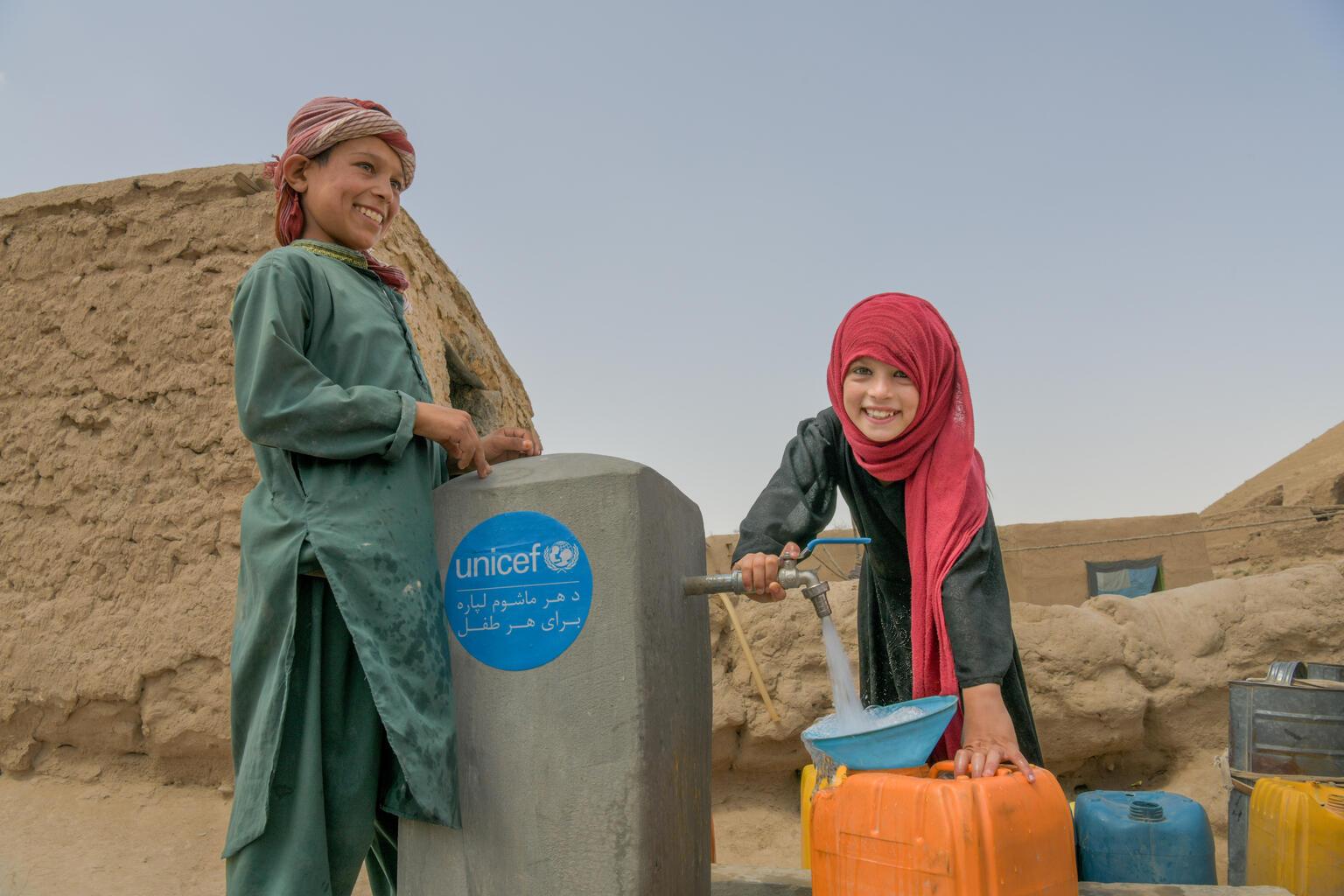 kinderen bij waterpomp met schoon drinkwater