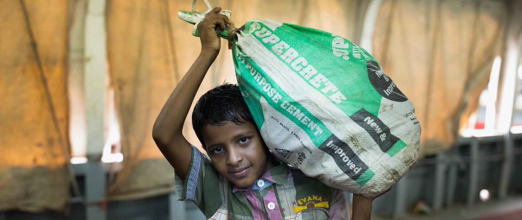 De 12-jarige Mohsin in Bangladesh werkt als sjouwer in Dhaka om bij te dragen aan het inkomen van zijn gezin. Zijn vader is riksjarijder en zijn moeder huisvrouw.
