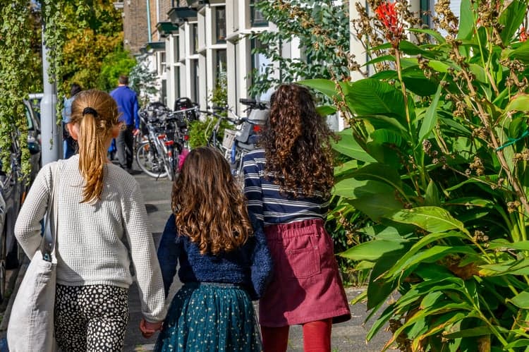 drie meisjes op straat op de rug gezien