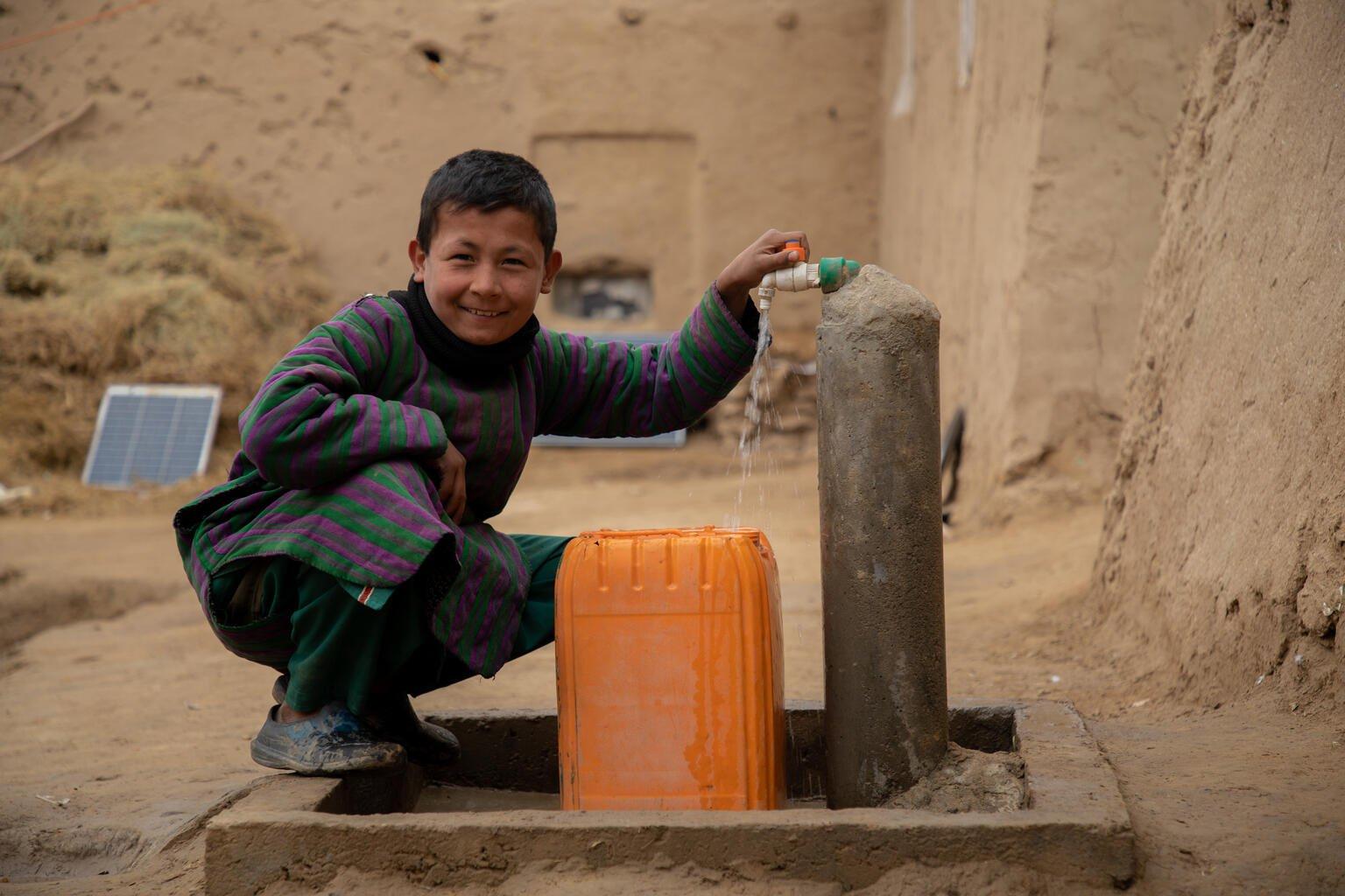jongen met jerrycan bij pomp